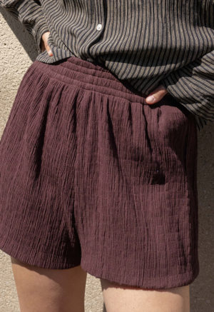 woman in dark chocolate brown shorts and black and white button-up shirt