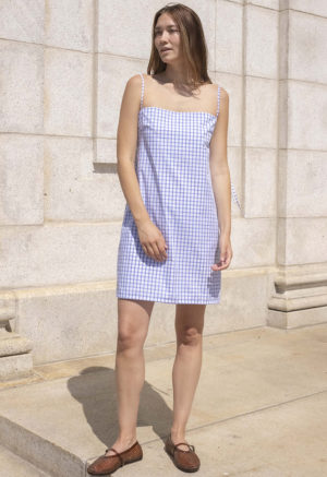 woman in white and blue window pane slip dress with brown jelly shoes