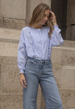 woman in blue and white checkered button-up and jeans