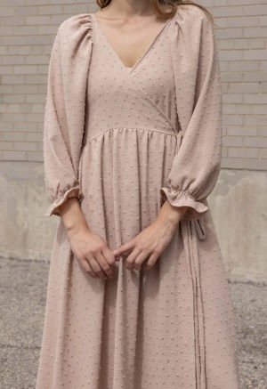 woman in blush wrap dress