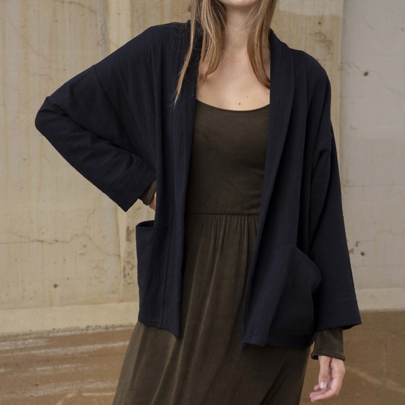 woman in dark brown midi length dress and black oversized jacket