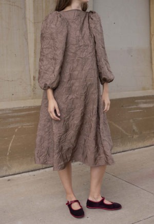 woman in crinkle fabric boatneck mauve balloon sleeve midi swing dress