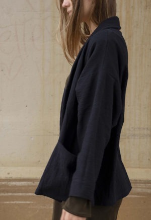 woman in dark brown midi length dress and black oversized jacket