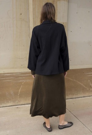 woman in dark brown midi length dress and black oversized jacket