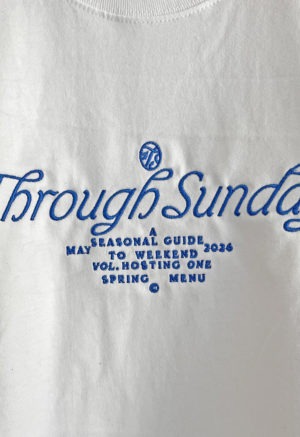 white t-shirt with blue embroidery on front chest