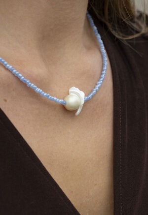 woman in blue pearl and shell necklace