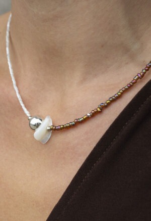 woman wearing half white half brown necklace