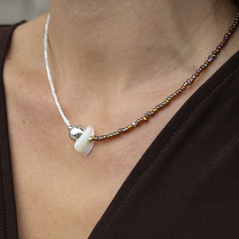woman wearing half white half brown necklace