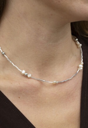 pearl and silver necklace on white backdrop