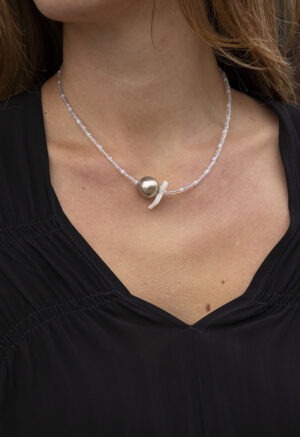 woman in black v-neck with silver and clear beaded necklace
