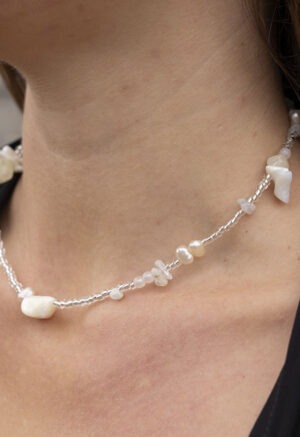 woman in black v-neck and clear and white beaded necklace