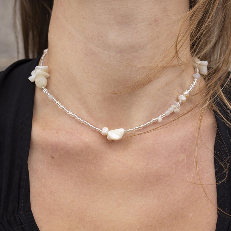 woman in black v-neck and clear and white beaded necklace