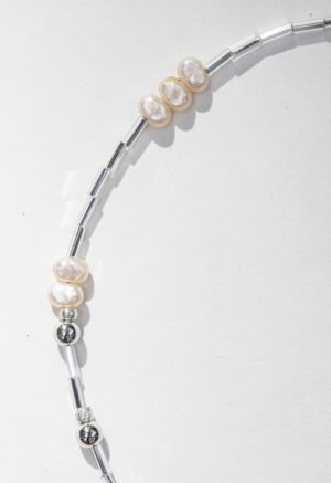pearl and silver necklace on white backdrop