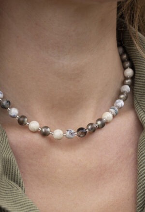 woman in green button-up with round beaded necklace