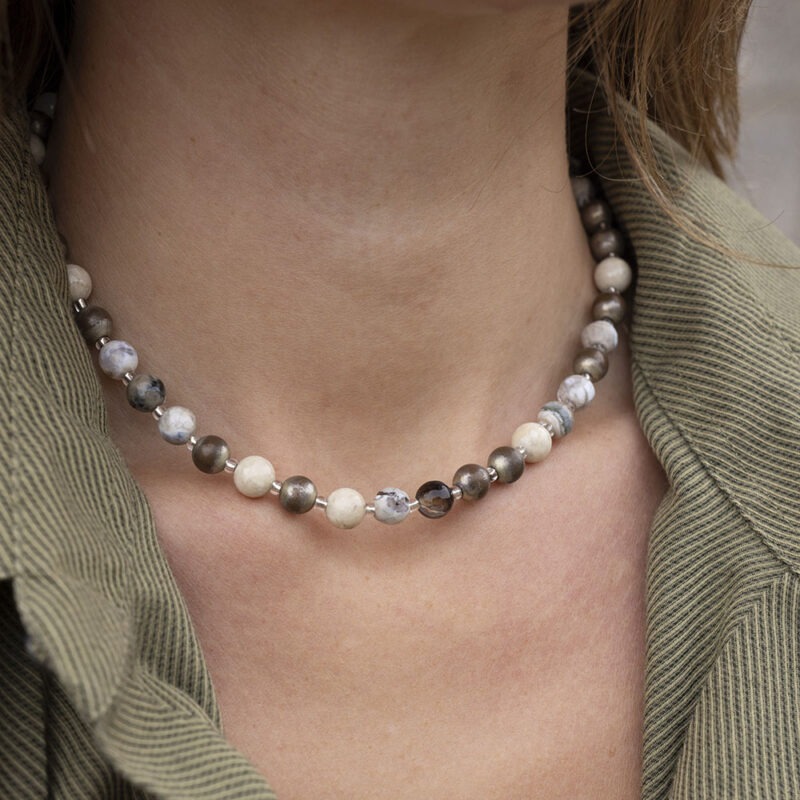 woman in green button-up with round beaded necklace