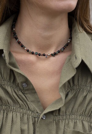 woman in green button-up with dark green and black beaded necklace