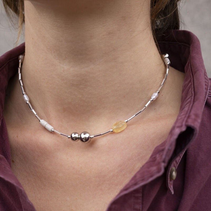 woman in maroon button-up and silver and stone necklace