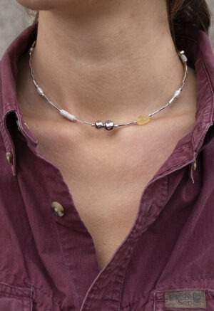 woman in maroon button-up and silver and stone necklace