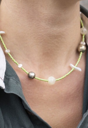 woman in green button-up with green beaded necklace