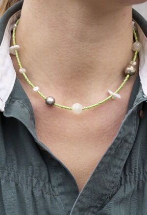 woman in green button-up with green beaded necklace