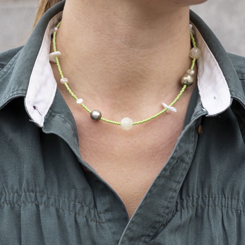 woman in green button-up with green beaded necklace