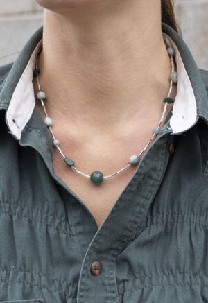 woman in green button-up shirt and beaded necklace