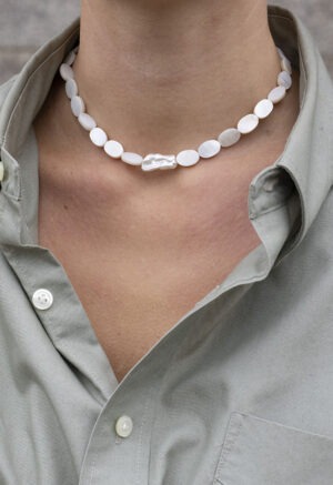 woman in grey shirt and pearl necklace