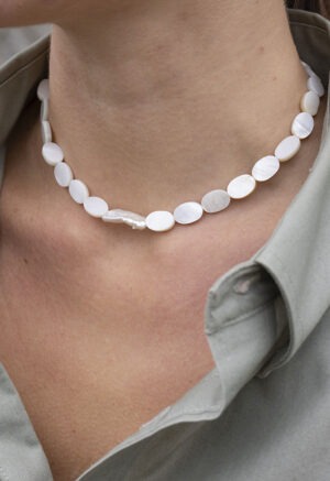 woman in grey shirt and pearl necklace