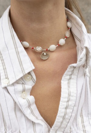 woman in white strip button-up and beaded shell necklace