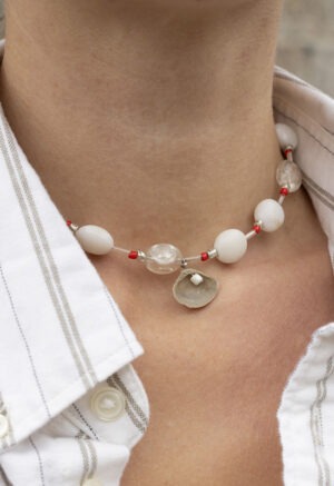 woman in white strip button-up and beaded shell necklace