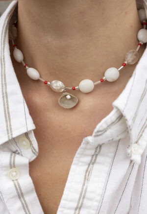 woman in white strip button-up and beaded shell necklace