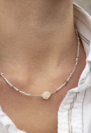 woman in white stripe button-up and silver necklace