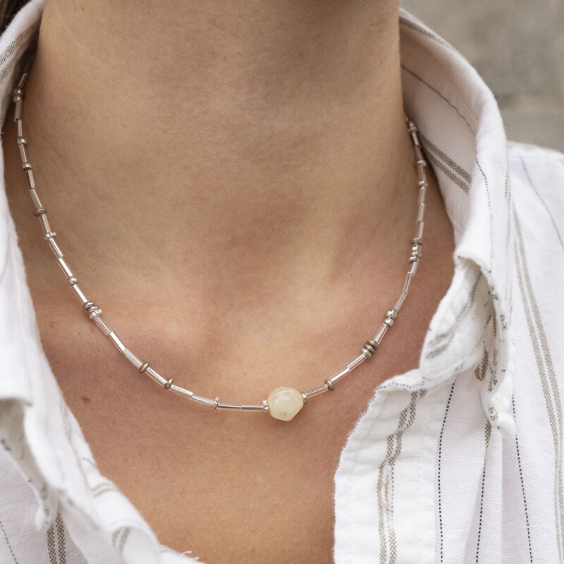 woman in white stripe button-up and silver necklace