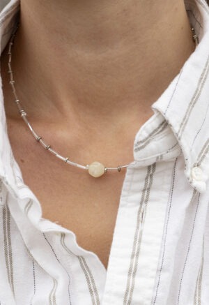 woman in white stripe button-up and silver necklace