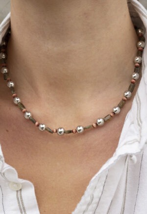 Silver, green and red necklace on woman in stripe button-up