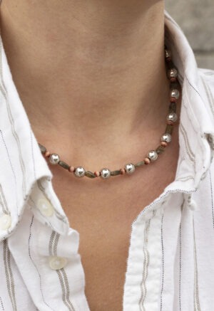 Silver, green and red necklace on woman in stripe button-up