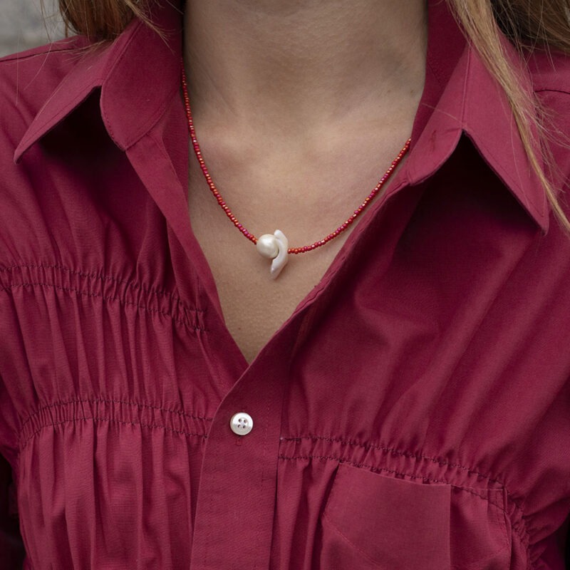 woman in red necklace with red button-up