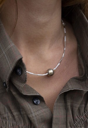 woman in brown plaid shirt and pearl and silver necklace