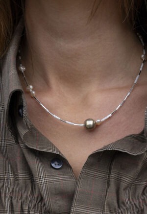 woman in brown plaid shirt and pearl and silver necklace
