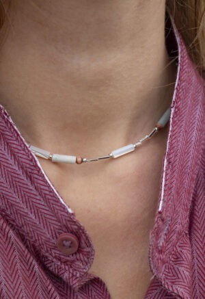 red button-up and necklace of light green, red and silver beads