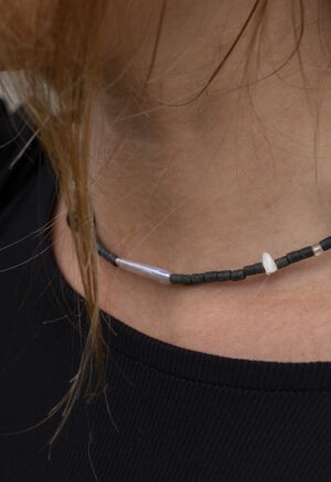 Woman wearing black necklace with black and pearl beads