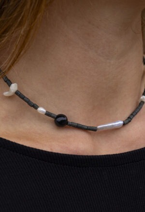 Woman wearing black necklace with black and pearl beads
