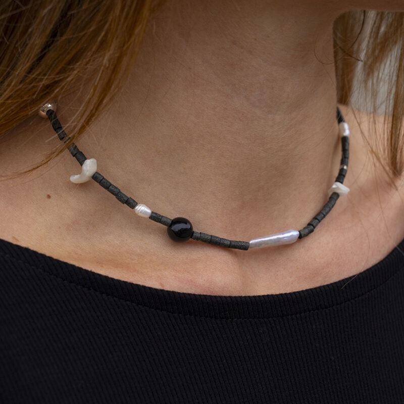 Woman wearing black necklace with black and pearl beads