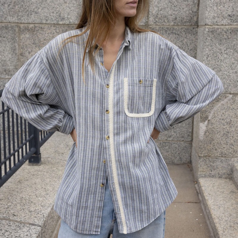 woman in blue and white stripe button-up and jeans