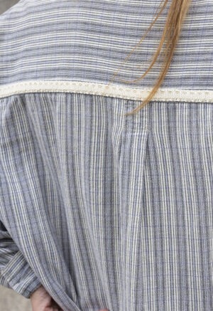 woman in blue and white stripe button-up and jeans