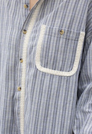 woman in blue and white stripe button-up and jeans