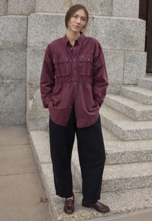 woman in maroon button-up and black trousers