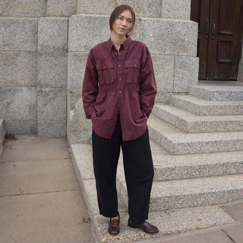 woman in maroon button-up and black trousers