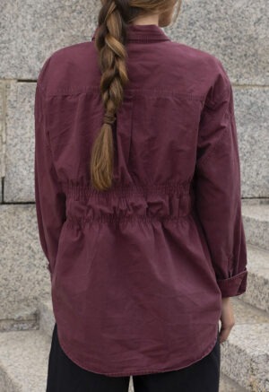 woman in maroon button-up and black trousers