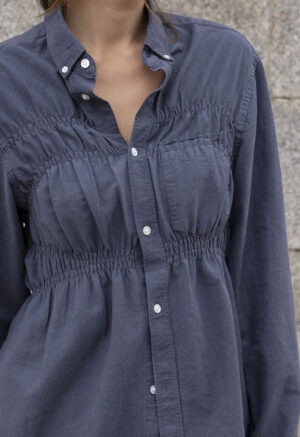 woman in dark grey button-up and black pants